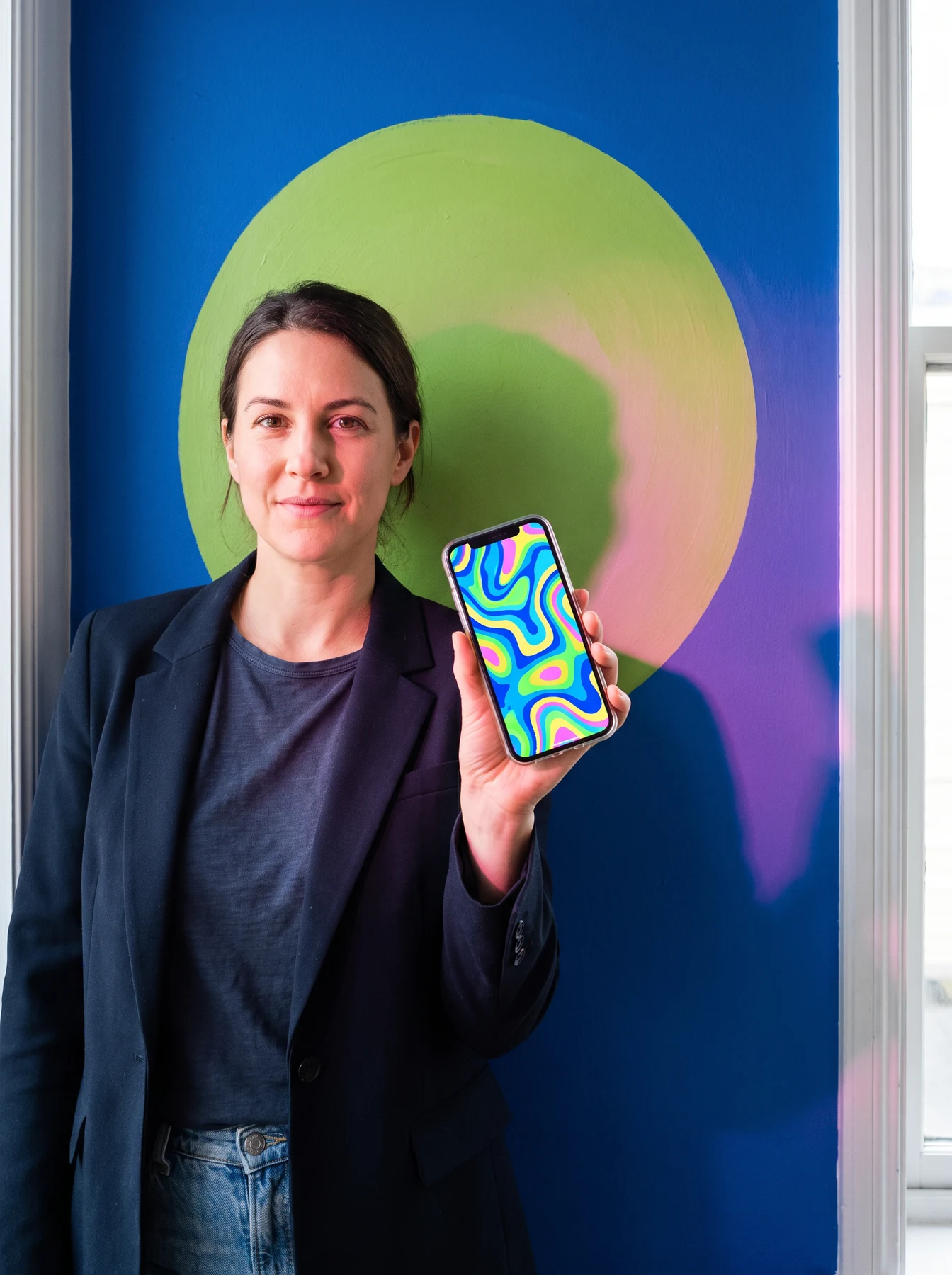 Person holding a smartphone with abstract colourful interface